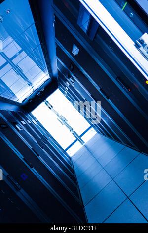 Sleek data center corridor showcasing rows of server racks under bright light. This image captures the essence of modern technology and digital infras Stock Photo