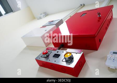 A red emergency control panel featuring buttons and indicators, designed for safety and alert systems in industrial environments. Ideal for emergency Stock Photo