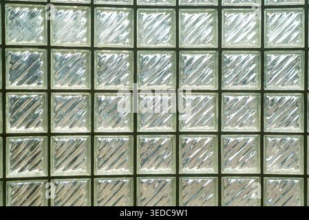 The image features a glass block wall showcasing unique texture and reflective patterns, creating a modern aesthetic perfect for interior design proje Stock Photo
