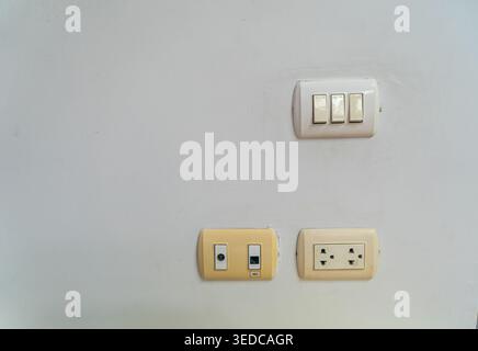 A close-up view of electrical switches and outlets mounted on a plain wall, highlighting their design, functionality, and integration into interior sp Stock Photo