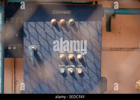 A close-up view of a control panel for a water pump, showcasing various buttons and switches used in industrial applications for water management. Stock Photo