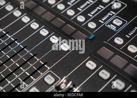 Close-up view of an audio mixer control surface featuring knobs and buttons. The image captures essential functionalities for sound mixing and music p Stock Photo
