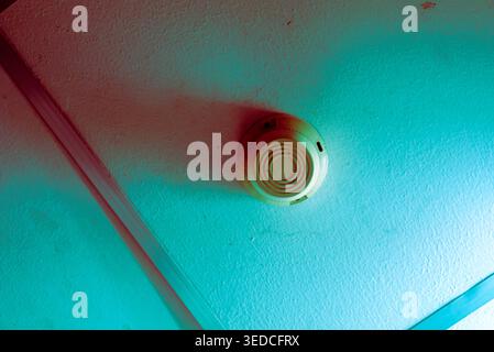 A colorful close-up of a ceiling-mounted smoke detector, showcasing modern safety technology. Ideal for home safety and fire prevention themes. Stock Photo