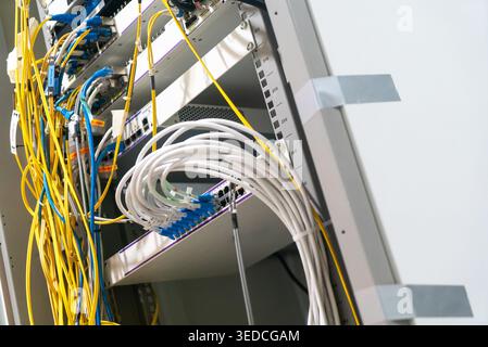 A detailed view of a data center rack showing organized and chaotic cables. This image captures the complexity of network connections and installation Stock Photo