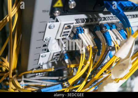 Detailed view of network cabling and equipment in a server room, showcasing connections and organization of wires, essential for modern communication Stock Photo