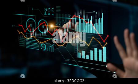 A user interacts with a digital analytics dashboard displaying financial graphs and data visualizations, showcasing modern technology and business Stock Photo