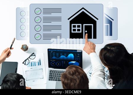 A professional business meeting focused on real estate analysis featuring charts and data insights. Team members collaborate to make informed Stock Photo