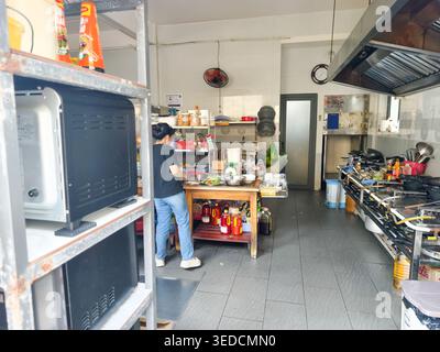 typical small commercial kitchen in Vietnam, featuring a stainless steel work station and industrial cooking equipment. Phu Quoc Stock Photo