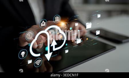 Hands of a Business Person Using a Tablet with Cloud Technology Icons Representing Data Transfer and Digital Storage Solutions Haptic. Stock Photo