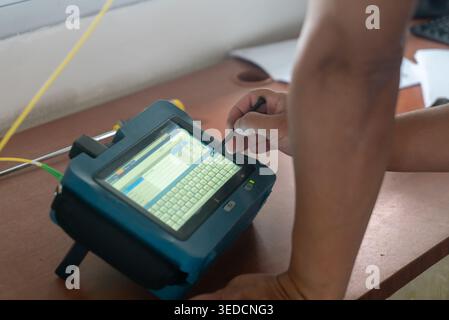 A close-up view of a hand interacting with a touchscreen device in a modern office environment, showcasing technology in data input and communication Stock Photo