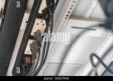 An overhead view of electrical power outlet with multiple plugs connected. This image showcases wiring and device connections in a modern setup. Perfe Stock Photo