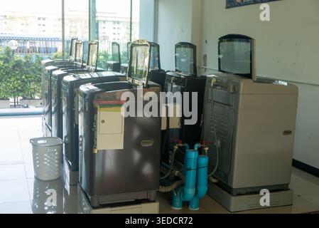 A modern laundromat featuring washing machines arranged in a bright, clean interior. This space highlights the convenience of laundry service in urban Stock Photo