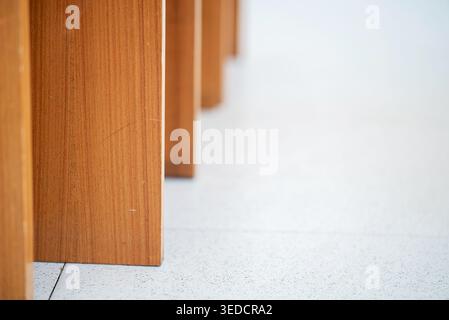 A close-up view of a wooden table leg showcases the rich texture and warm tones of the surface. Perfect for interior design and furniture aesthetics. Stock Photo