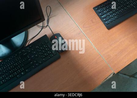 Aerial view of a modern computer desk featuring two black keyboards and a mouse. Ideal for showcasing technology in office or home workspace design. Stock Photo