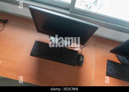 A modern empty computer desk featuring a monitor, keyboard, and mouse. Ideal for showcasing workspace technology in a professional setting. Stock Photo