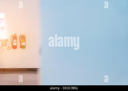 A close-up image of fire extinguishers mounted on a wall, highlighting the importance of fire safety in indoor settings and emergency preparedness. Stock Photo