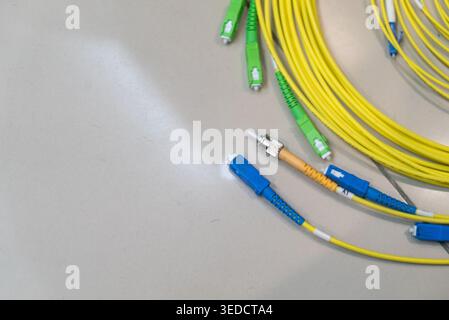 Close-up view of colorful fiber optic cables and connectors on a surface, highlighting essential components for modern networking and communication te Stock Photo