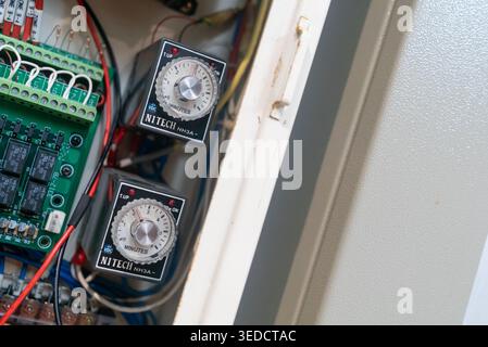 Close-up view of an electrical control panel showcasing timers and wiring. Ideal for representations of technology and industrial systems. Stock Photo