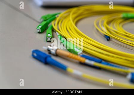 This close-up image showcases various fiber optic cables in vibrant yellow and green colors, highlighting the intricate connections essential for high Stock Photo