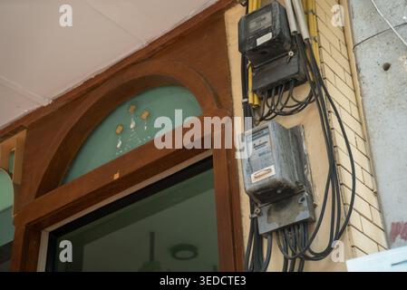 A detailed view of electric meters mounted on a building's exterior, showcasing urban architectural elements and essential utility installations. Stock Photo