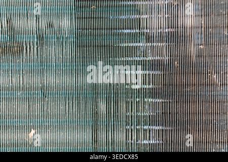 Close-up view of a metallic surface featuring vertical lines, creating an abstract industrial pattern. Ideal for backgrounds and contemporary design p Stock Photo