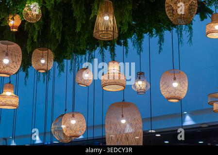 Beautiful hanging light fixtures create a cozy atmosphere in a stylish indoor space, featuring woven rattan designs that add warmth and elegance. Stock Photo