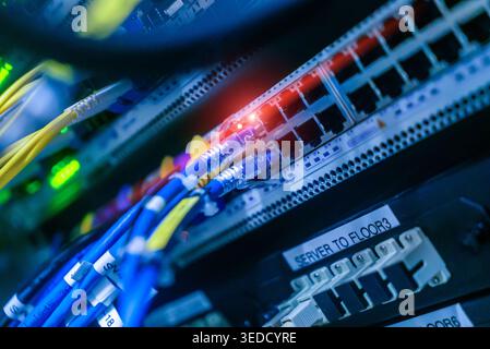 A close-up image showcasing a server rack filled with colorful network cables, illuminated by vibrant LED lights, highlighting modern technology in da Stock Photo