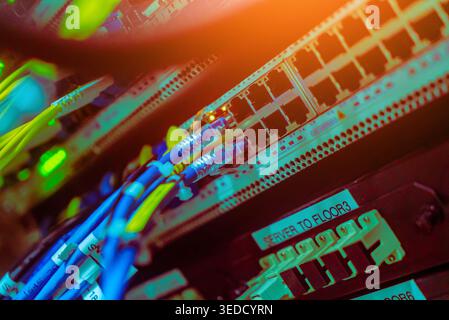 A close-up view of colorful fiber optical cables connecting to network servers in a rack, illustrating modern technology and efficient data transmissi Stock Photo