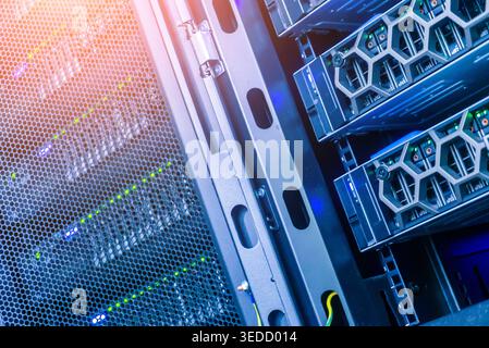 This image captures a detailed view of a server rack featuring advanced data storage and networking equipment. The vibrant lighting highlights the mod Stock Photo