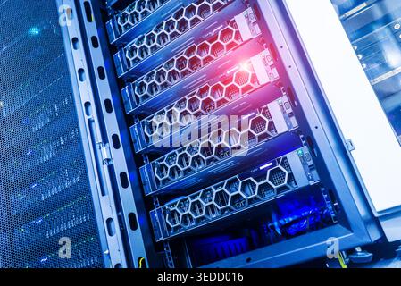 A view of a high-tech data center showcasing multiple computer servers in a secure rack. Bright lights highlight the advanced technology, emphasizing Stock Photo