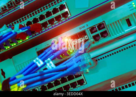 Detailed view of network infrastructure showing colorful cables and switches in a modern server room, emphasizing connectivity and data management. Stock Photo