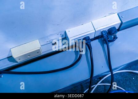 Image of a power strip with multiple cords connected, showcasing electrical wiring in a modern indoor environment. Ideal for technology and utility th Stock Photo