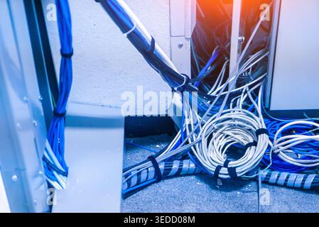 A closeup view of tangled network cables in a technology environment, highlighting the complexity and messiness often found in data management setups. Stock Photo