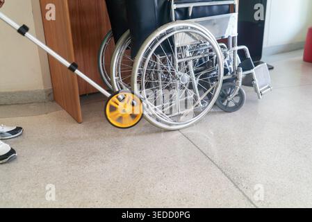 A caregiver uses a wheelchair in a healthcare facility, showcasing the importance of mobility assistance for patients in need of support and care. Stock Photo