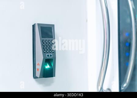 A modern biometric access control device mounted on a wall, featuring a sleek design and user-friendly interface for secure entry and identification. Stock Photo