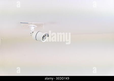 This image showcases a modern surveillance camera mounted on a ceiling, featuring a sleek design and advanced technology for optimum security and moni Stock Photo