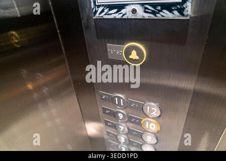 Close-up of an elevator control panel showcasing illuminated buttons for various floors, highlighting modern design and functionality in urban archite Stock Photo