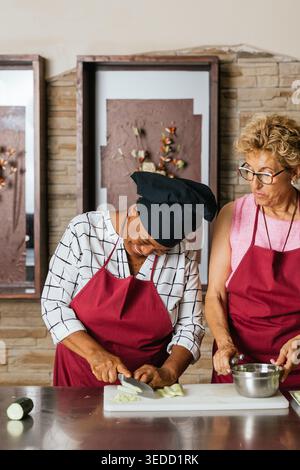 Chefs cutting vegetables during cooking course in restaurant kitchen Stock Photo