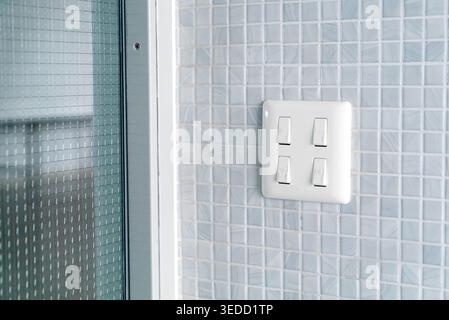 This image showcases a sleek light switch mounted in a bright bathroom, highlighting modern design elements with a clean and contemporary aesthetic. Stock Photo