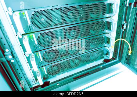 This image showcases a high-tech server rack featuring multiple cooling fans, essential for optimal data processing and storage in modern IT infrastru Stock Photo