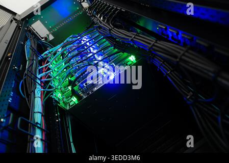 A detailed view of colorful network cables and glowing lights inside a modern data center. This image captures the essence of technology and organizat Stock Photo