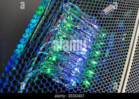 This image showcases a vibrant circuit board inside a server rack, with luminous lights illuminating various components. A representation of modern te Stock Photo