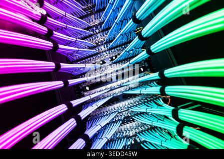 Vibrant fiber optic cables illuminated in a server rack create a dynamic network infrastructure, showcasing modern technology and innovation in data t Stock Photo