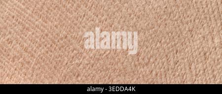 Light brown background from soft fluffy textile material macro. Texture of beige plush fabric backdrop. Wavy pattern. Stock Photo
