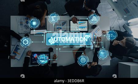 A diverse business team collaborates on automation strategies in a modern conference room, utilizing digital icons and data visuals to enhance Stock Photo