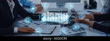 A business team works together in a modern office setting, focusing on strategies for automation while integrating various digital tools and icons to Stock Photo