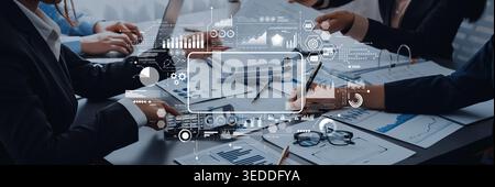 Business professionals collaborate in an office setting, analyzing reports and using technology to drive informed decision-making and strategy Stock Photo