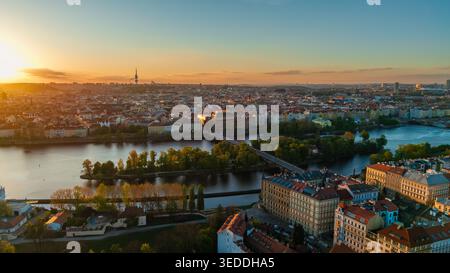 Aerial view of the Vltava River and historic skyline during golden hour sunset with bridges and lush greenery in Prague, Prague, Czechia. Stock Photo