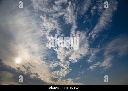 Sunlight shines through cirrus clouds in the morning sky. Stock Photo