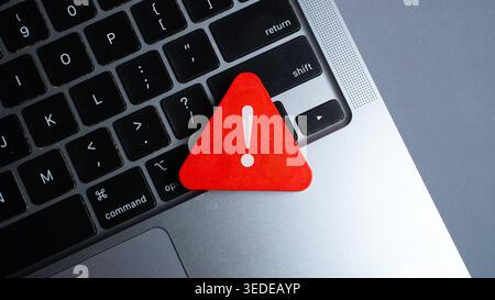 Red Warning Triangle with Exclamation Mark on Laptop Keyboard Highlighting Cyber Security Risk or System Error Stock Photo